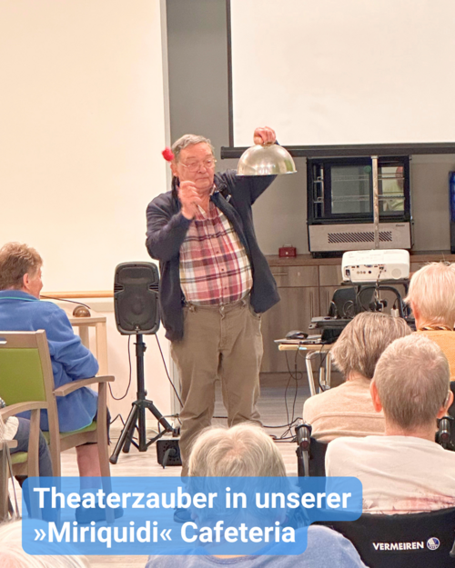 Eine Gruppe älterer Menschen ist bei einer Theateraufführung, bei der Soundeffekte vorgeführt werden. Hier sieht man eine Metallglocke, die anscheinend “geläutet” wird. Bildbeschriftung: Theaterzauber in unserer »Miriquidi« Cafeteria